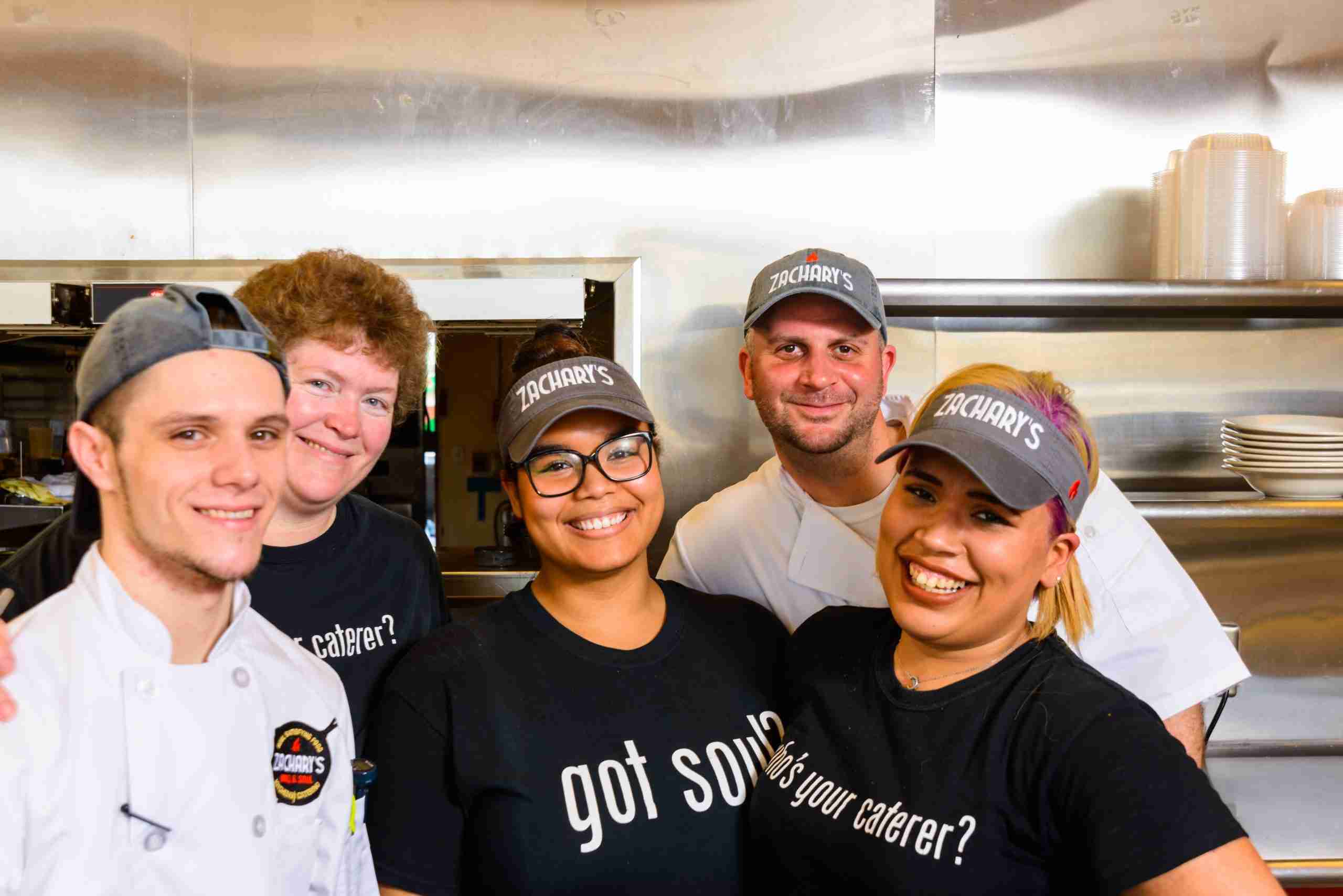 Staff Zachary's BBQ catering team in the kitchen wearing branded uniforms in Collegeville PA